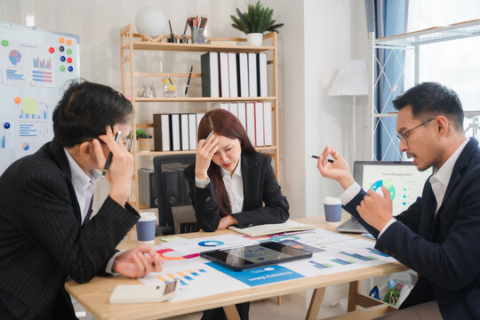 Stressful Business Meeting: A team of three business professionals grapples with challenges during a tense meeting.  The image portrays the weight of decision-making and the pressure of deadlines.