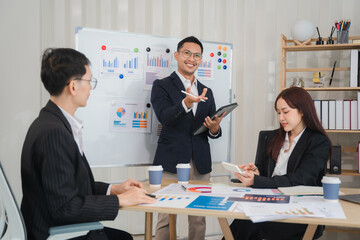 Confident Business Presentation: A charismatic male leader confidently presents data to a focused team during a productive meeting.  The image exudes professionalism and collaboration. 