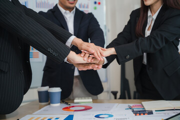 Teamwork Makes the Dream Work: A close-up shot of a diverse business team, hands clasped together in a powerful symbol of unity, collaboration, and shared ambition. The image evokes a sense of trust.