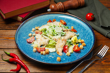 Caesar salad on a plate, cafe, restaurant, on a wooden table.