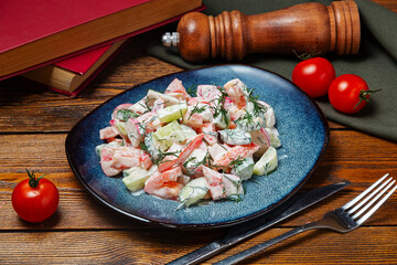 Salad of fresh vegetables tomatoes and cucumber with sour cream on a plate, cafe, restaurant, on a wooden table.
