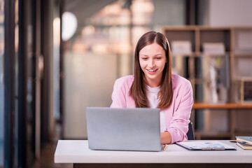 Fototapeta premium Beautiful professional woman sitting at table smiling while reading important documents with financial graphs and accounting of company.