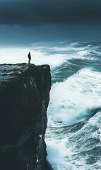 A lone figure stands on a cliff overlooking stormy waves.