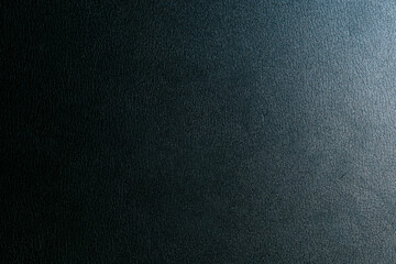 鈍い光の当たった光沢のある黒い革の表面　テクスチャー背景壁紙　ざらざらの質感