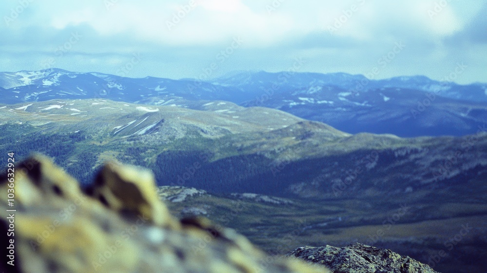 Sticker Stunning Mountain Landscape: Expansive View of Rolling Hills and Clouds with Rocky Foreground - Ideal for Nature Themes