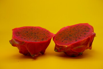 a dragon fruit cut in half. dragon fruit isolated on yellow background