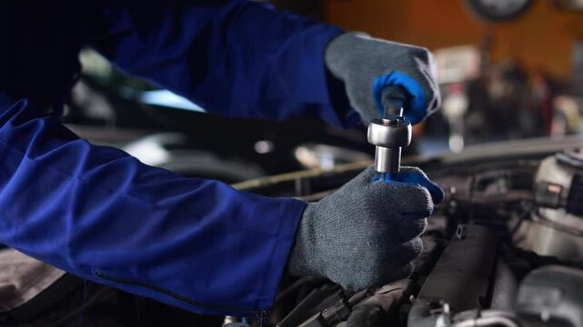 Slowmotion. Close up mechanical hand with tools and spanner. Hispanic latin male mechanic repairs car in garage. Car maintenance and auto service garage concept
