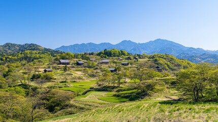 Fototapeta premium Serene Beauty of Ancient Japan: Scenic Valley with Traditional Farmhouses, Mountains, and Blue Sky