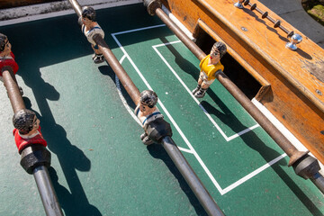A close-up view of the table football game of football figures on the field. foosball table soccer. Mini football players sport team