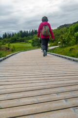 Obraz premium Woman walking on a wooden path in pingvellir National Park, Iceland
