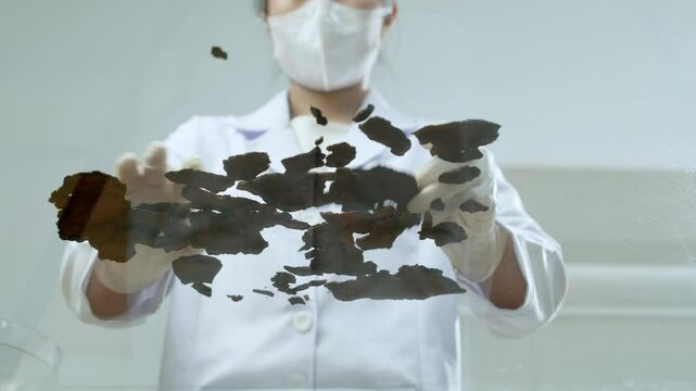 Video template with its bottom-up perspective, ideal for contemporary scientific experiments in which a researcher mixes portions of dried herbs on a transparent glass table.