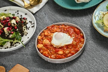 Gourmet dishes with shakshuka and salad.