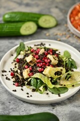 Fresh salad with black lentils and pomegranate seeds.