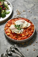 Delicious shakshuka with poached eggs and salad.