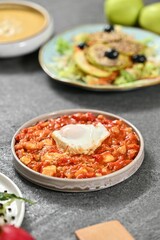 Shakshuka with Poached Egg on Stone Table