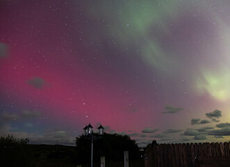 The Aurora Borealis, the northern lights, showing up above fence and lamp in County Donegal, Ireland