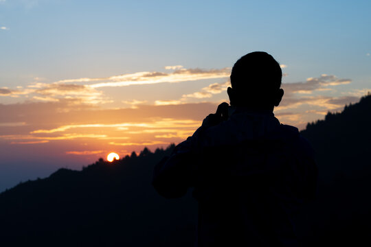 Beautiful sunrise with the silhouette of people and mountain landscape shot. 