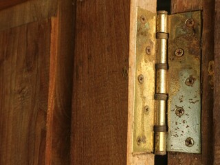 The rusted hinges are attached to the door leaf