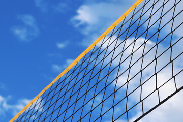Beach volleyball net close-up. Fragment of a volleyball net on the beach against the blue sky. Sport, beach volleyball. Active recreation concept. Background. Detail of the yellow net. Sports ground
