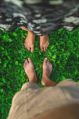 Legs of a woman and a man on the grass. Selective focus.