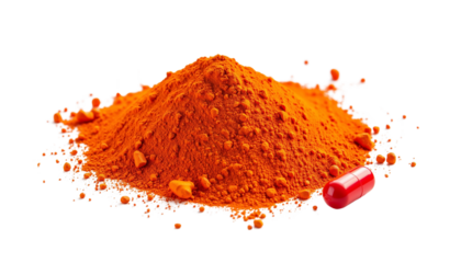 Bright Orange Spice Powder Piled Next to a Red Capsule on White Surface