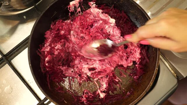 Grated beets are fried in a pan. Preparation of borscht.