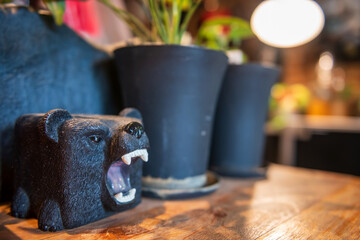 Black bear model decor on table by tree pot at cafe and restaurant