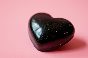 Obraz premium Black heart candy on a pink background. Valentine's day. Love.