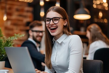 A businesswoman sits in a cafe, laughing joyfully while working on her laptop, radiating a sense of happiness and productivity in her vibrant surroundings.