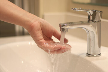 Woman washing her hands, close-up. Bathroom tap. Woman washing her hands over the sink in the...