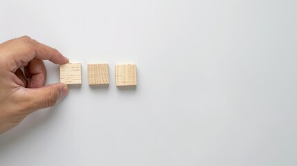 Hand placing wooden building blocks on white background, business and success concept.