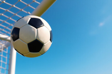 Soccer Ball Flying into Goal Net Against Blue Sky
