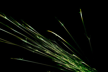 green sparks from the grinder glowing in the dark