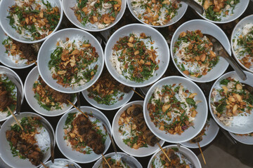 A vibrant display of soto with marinated meat skewers, garnished with fried shallots, green onions, and cilantro. This traditional Indonesian dish offers a rich, flavorful, and comforting meal.