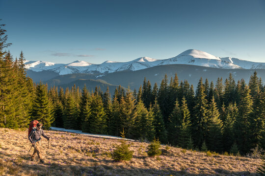 Man with Backpack On a Hiking Trip in Mountains at Sunset