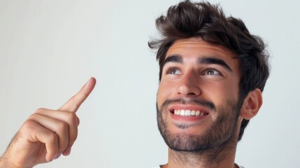 Cheerful man gesturing upwards in a studio setting, ready to announce promotional offers or giveaways against a blank background. Excited expression, showcasing a prize opportunity