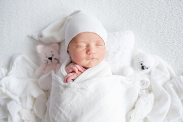 Newborn Girl Sleeps Under Blanket During Infant Photoshoot In Studio