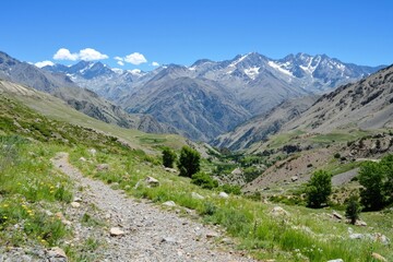 Breathtaking mountain landscape featuring winding trails and lush valleys on a sunny day