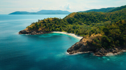 Close-up of island shore, aerial view, blue water lapping on the beach in the bay, lush vegetation on the island