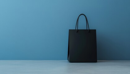 Minimalist black shopping bag against a soft blue background a fusion of style and simplicity in modern retail design