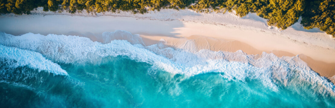 Aerial view of a white sandy beach and turquoise ocean waves, perfect for travel advertising. 