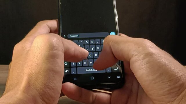 Close up view of hands typing message on mobile phone