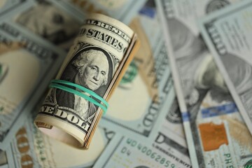 Obraz premium Money close up. A roll of one American dollars on 100 USD banknotes