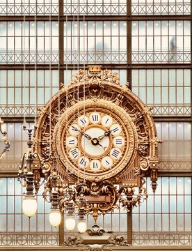 Paris, France: Orsay Museum Clock. An ornate gold clock set into the window wall of the old train station