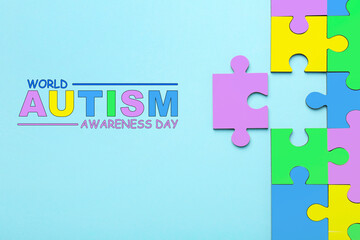 World Autism Awareness Day text and colorful puzzle pieces on light blue background, top view