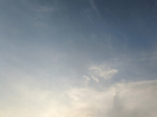 The sky has the light of the sun, the sky is blue, there are small and large clouds alternating and moving slowly, with the sunlight passing, creating a miraculous abstract shape, summer day.