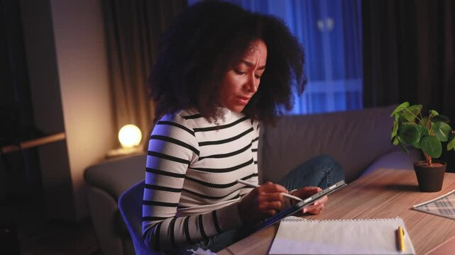 Sad young african american woman illustrator dissatisfied her drawing sketch from nature at digital tablet and expressively crossed out late at home Lack of inspiration and creative crisis concept