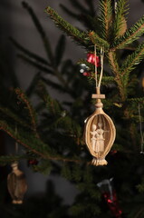 Handmade christmas tree decoration angel made of straw hanging on christmas tree branch.