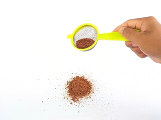 Hand sifting chili powder on white background