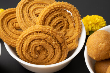 Crunchy fried homemade Chakli in a plate. Chakli is a savory snack from India made out of rice, mixed yellow and green lentils along with spices Diwali